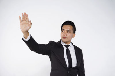 Young man standing against white background