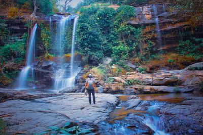 Man surfing on waterfall in forest