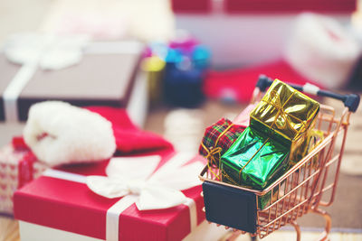 Close-up of multi colored gift boxes in shopping cart at home