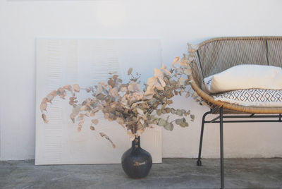 Flower vase on table against wall at home