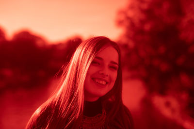 Portrait of smiling young woman against sky