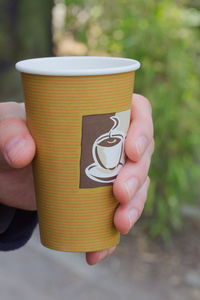 Close-up of hand holding coffee cup