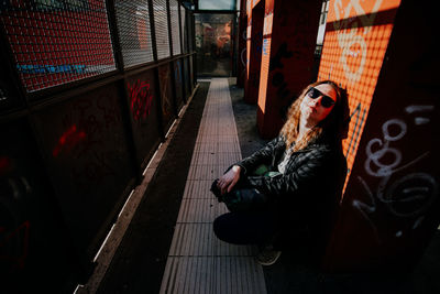 Rear view of young woman looking through window