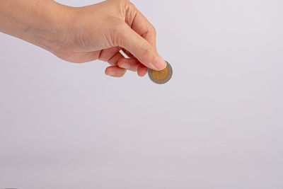 Midsection of person holding umbrella against white background