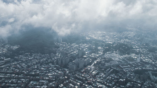 Aerial view of buildings in city against sky