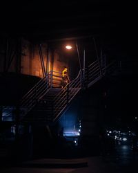 Man on illuminated bridge at night