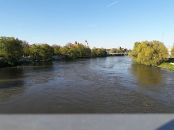 Scenic view of river against sky in city