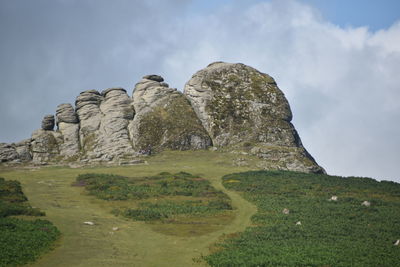 Low angle view of rocks on field against sky