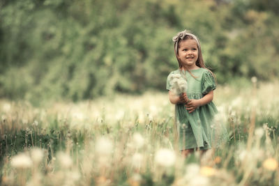 Portrait of smiling girl standing on field