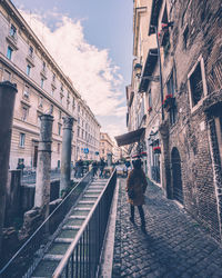 Man walking on bridge in city