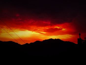 Scenic view of silhouette mountains against orange sky