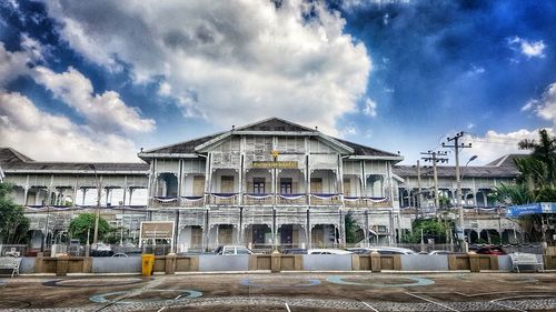 Facade of building against cloudy sky