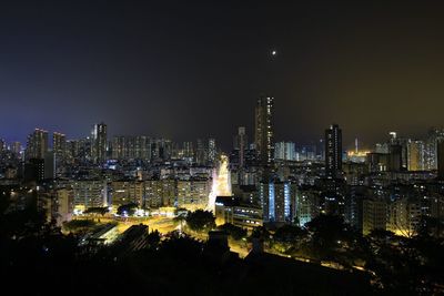 Illuminated cityscape against sky at night