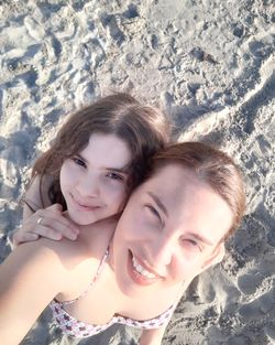 Portrait of smiling mother and daughter at beach