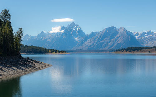 Scenic view of lake and mountains against blue sky