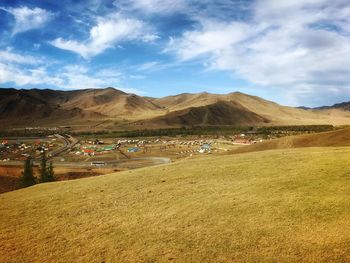Scenic view of field and mountains against sky