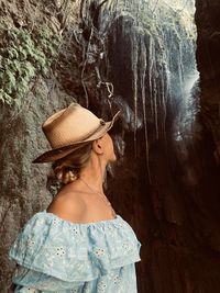 Woman wearing hat standing in cave