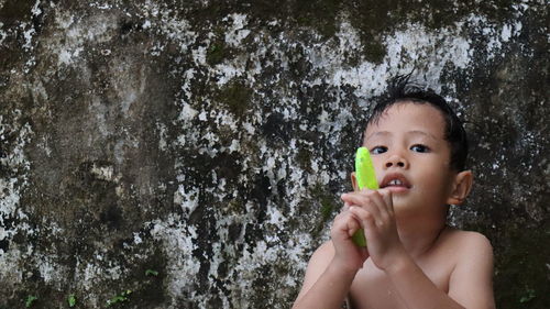 Portrait of shirtless boy drinking water