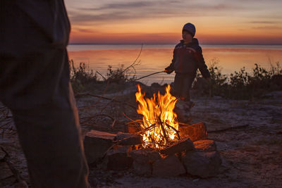 Bonfire on beach against sky during sunset