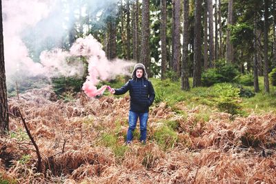 Full length of woman standing in forest