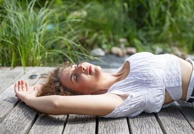 Portrait of young woman lying on boardwalk