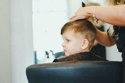 Profile of young boy getting a haircut in the salon