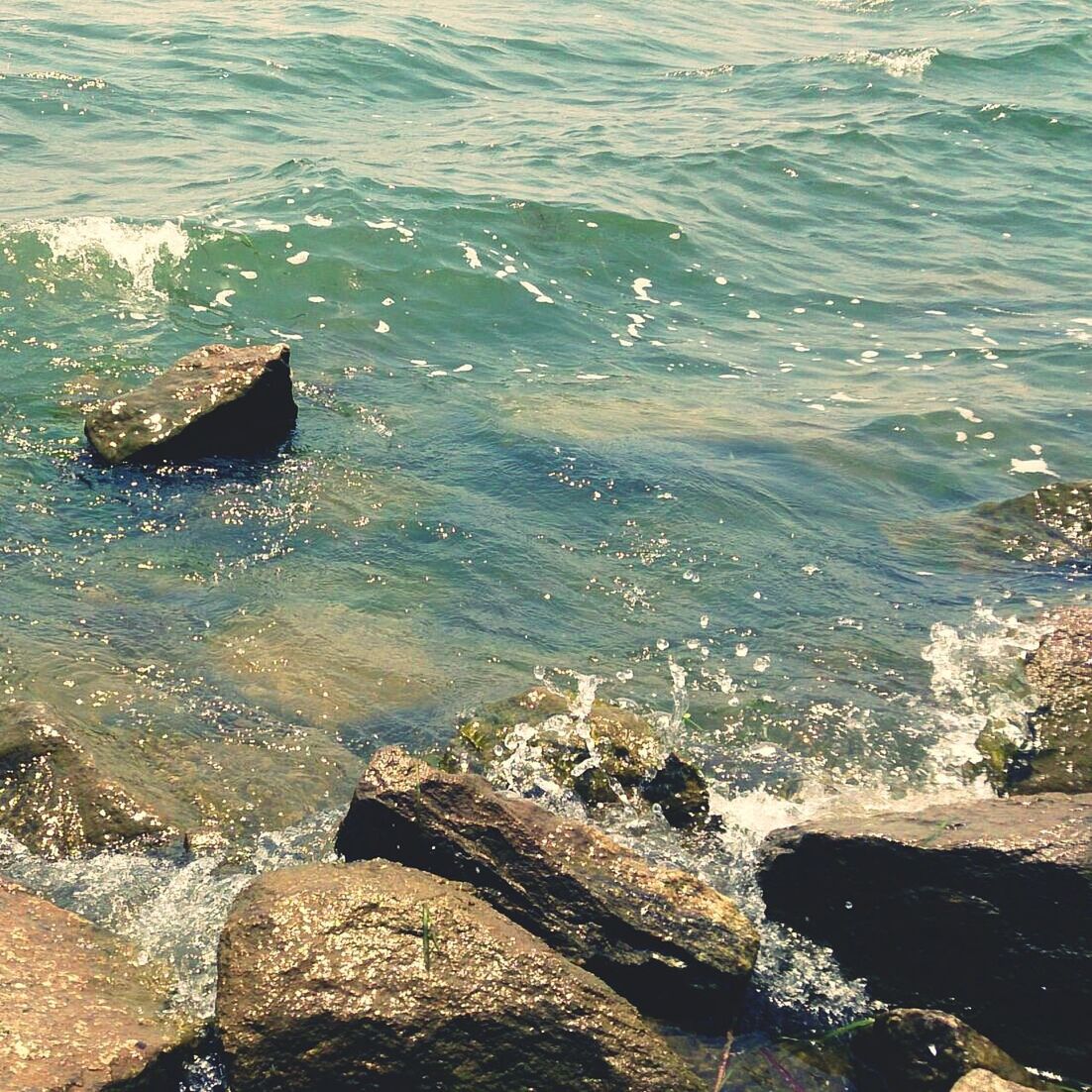 water, sea, wave, surf, high angle view, rock - object, nature, beauty in nature, shore, scenics, motion, rock formation, rippled, rock, sunlight, tranquility, outdoors, day, beach, splashing