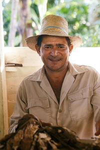 Portrait of mature man wearing hat standing in workshop