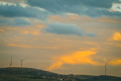 Silhouette of wind turbines at sunset