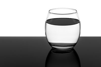 Close-up of beer glass on table against white background