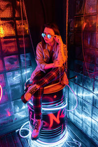 Portrait of young woman standing against wall