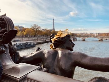 Statue of horse in water against sky