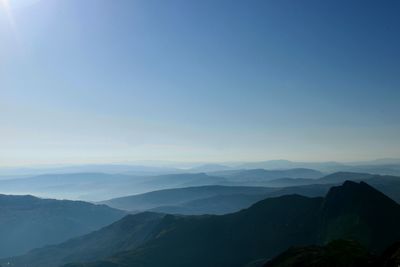 Scenic view of mountains against blue sky