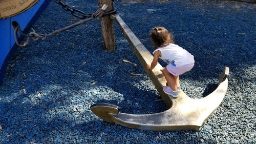 High angle view of baby girl climbing on anchor