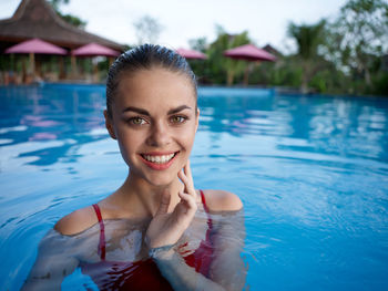 Portrait of smiling young woman in swimming pool