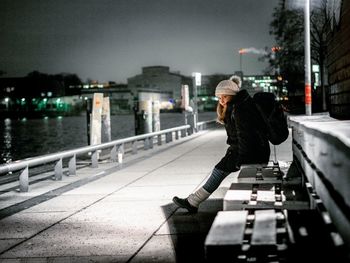 Woman with umbrella in city during winter