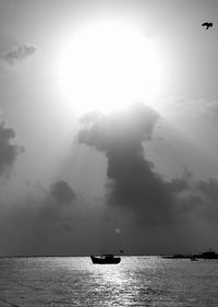 Silhouette boat sailing on sea against sky