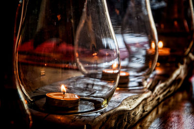 Close-up of illuminated tea light candle in container