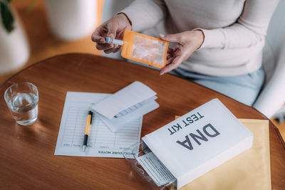 Senior woman preparing dna genetic test kit