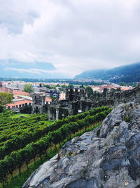 Buildings in city against cloudy sky