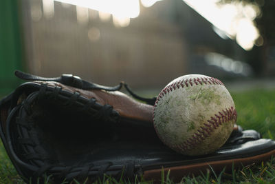 Close-up of baseball with glove on field