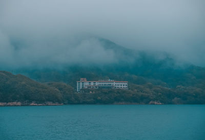 Scenic view of sea by buildings against sky