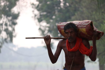 Man holding camera while standing outdoors
