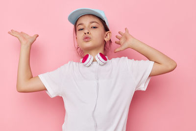 Portrait of girl dancing against pink background