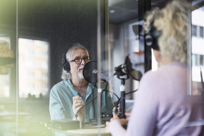 Male radio presenter talking with his guest on radio show or podcast