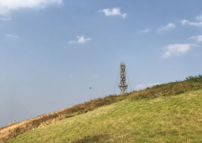 Low angle view of windmill on field against sky