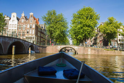 Swimming pool by canal against sky in city