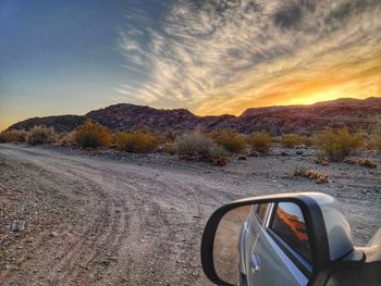 Car on road against sky during sunset