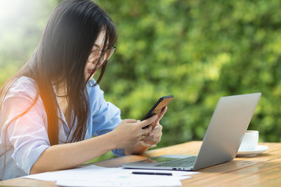 Midsection of woman using laptop on table