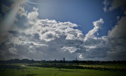 Scenic view of grassy field against cloudy sky